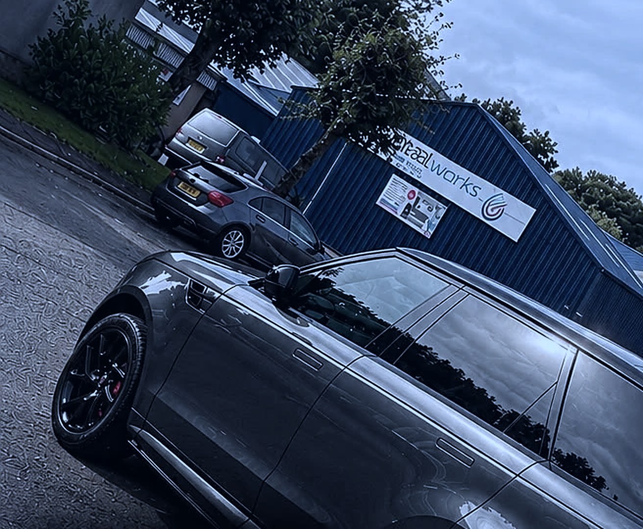 Grey Range Rover Sport parked outside an industrial unit